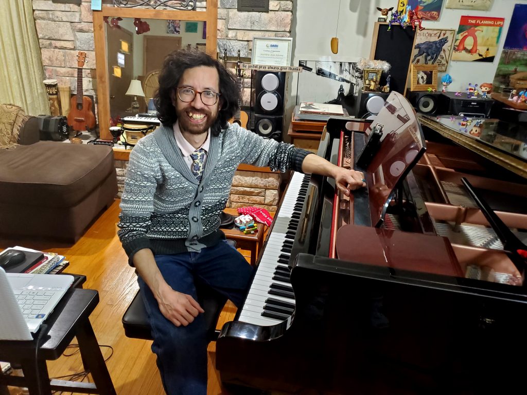 Matthew sits at his grand piano.